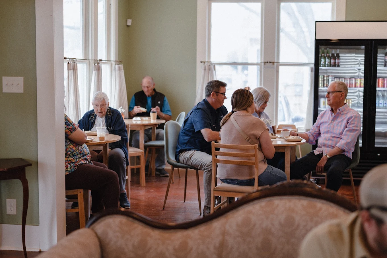 Neighbors of all ages sharing coffee and conversation at Selah's tables