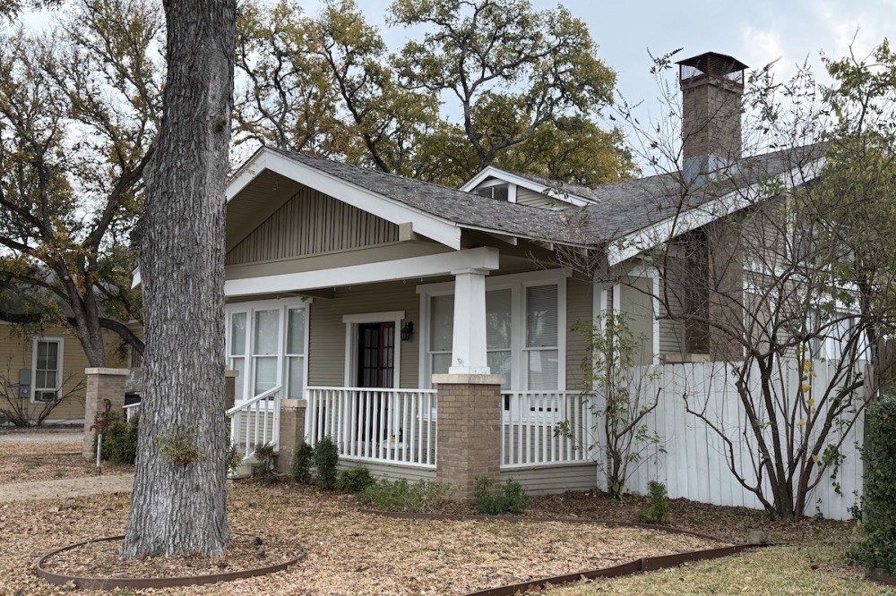 Selah Café's 1925 craftsman bungalow with a white front porch under live oaks